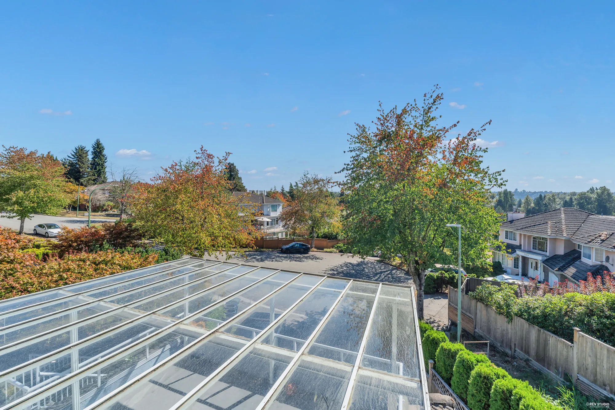 From the upper balcony, looking down over the glass roof of the terrace to the driveway and the street