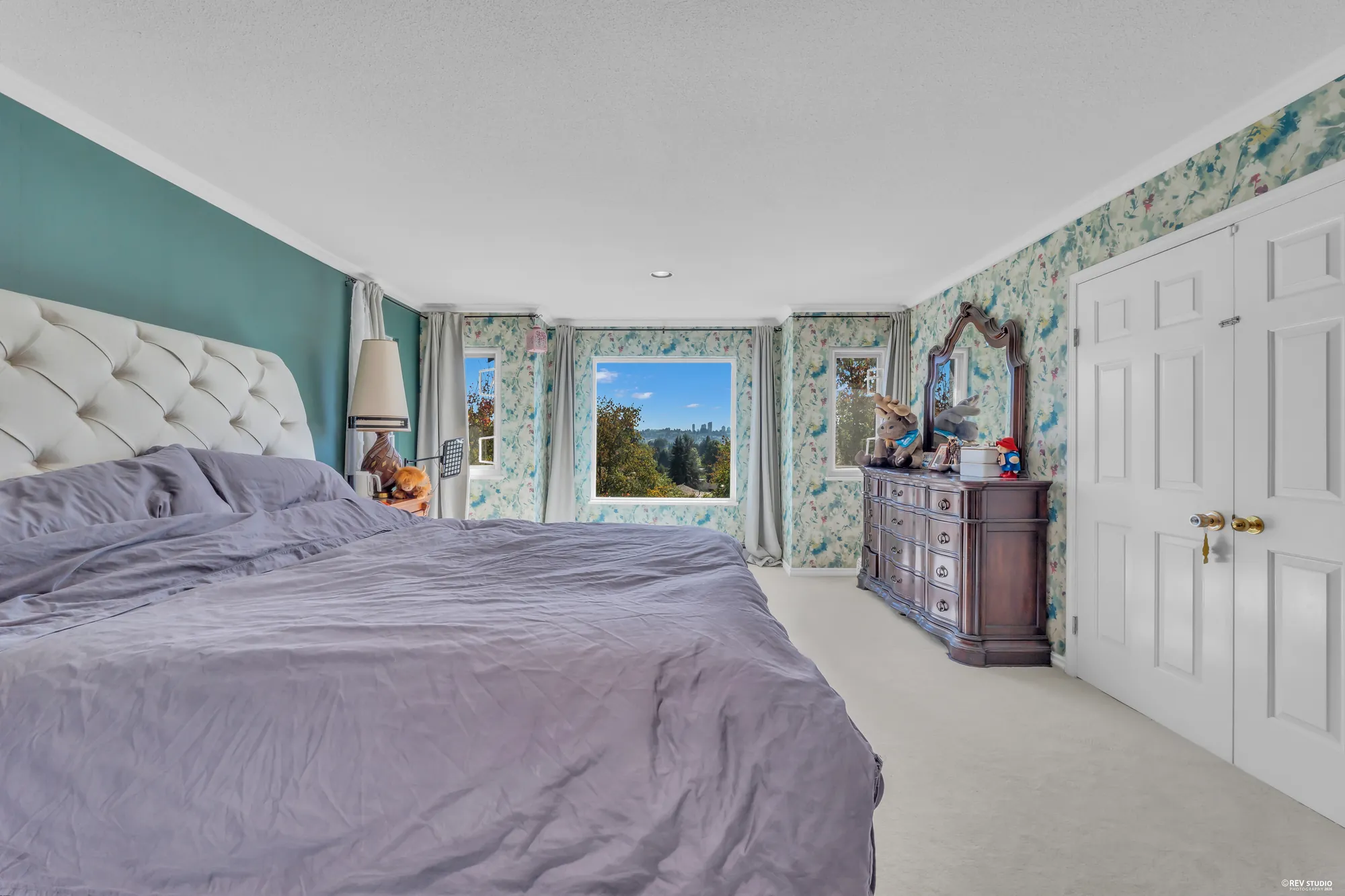 The same bedroom toward its windows and the dresser