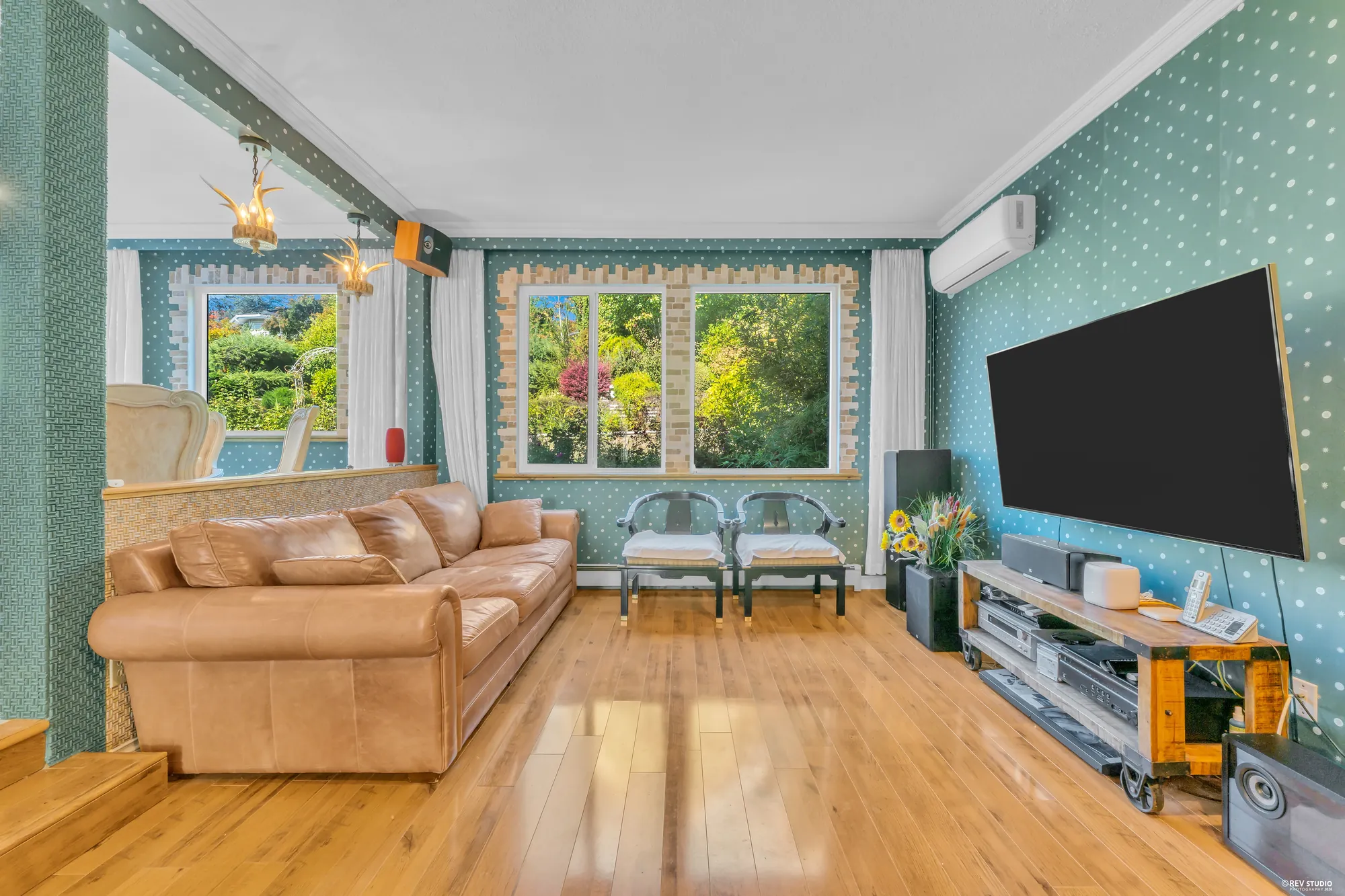 The family room toward its windows, the sofas and the television