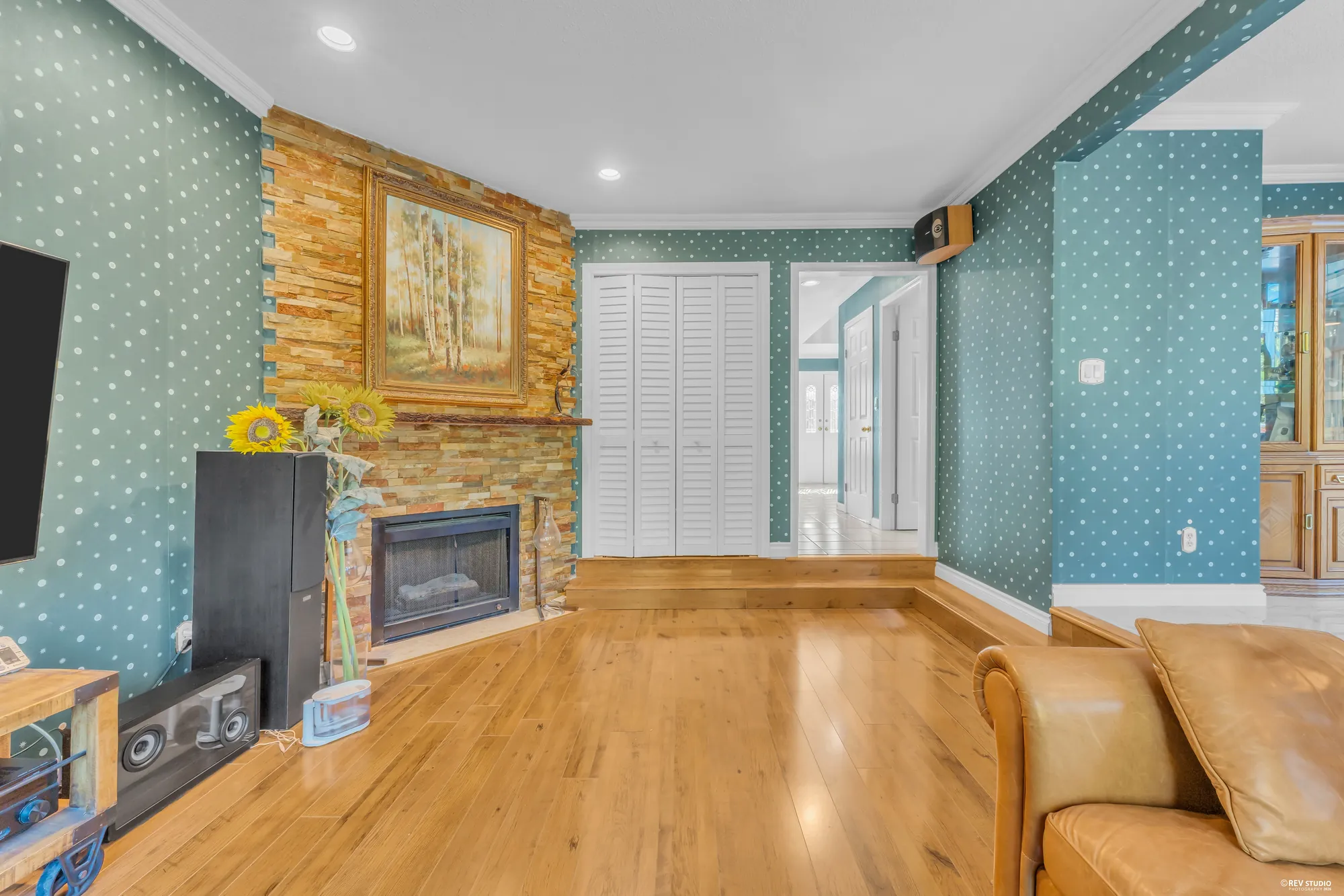 The stone fireplace with a painting above it and the television beside