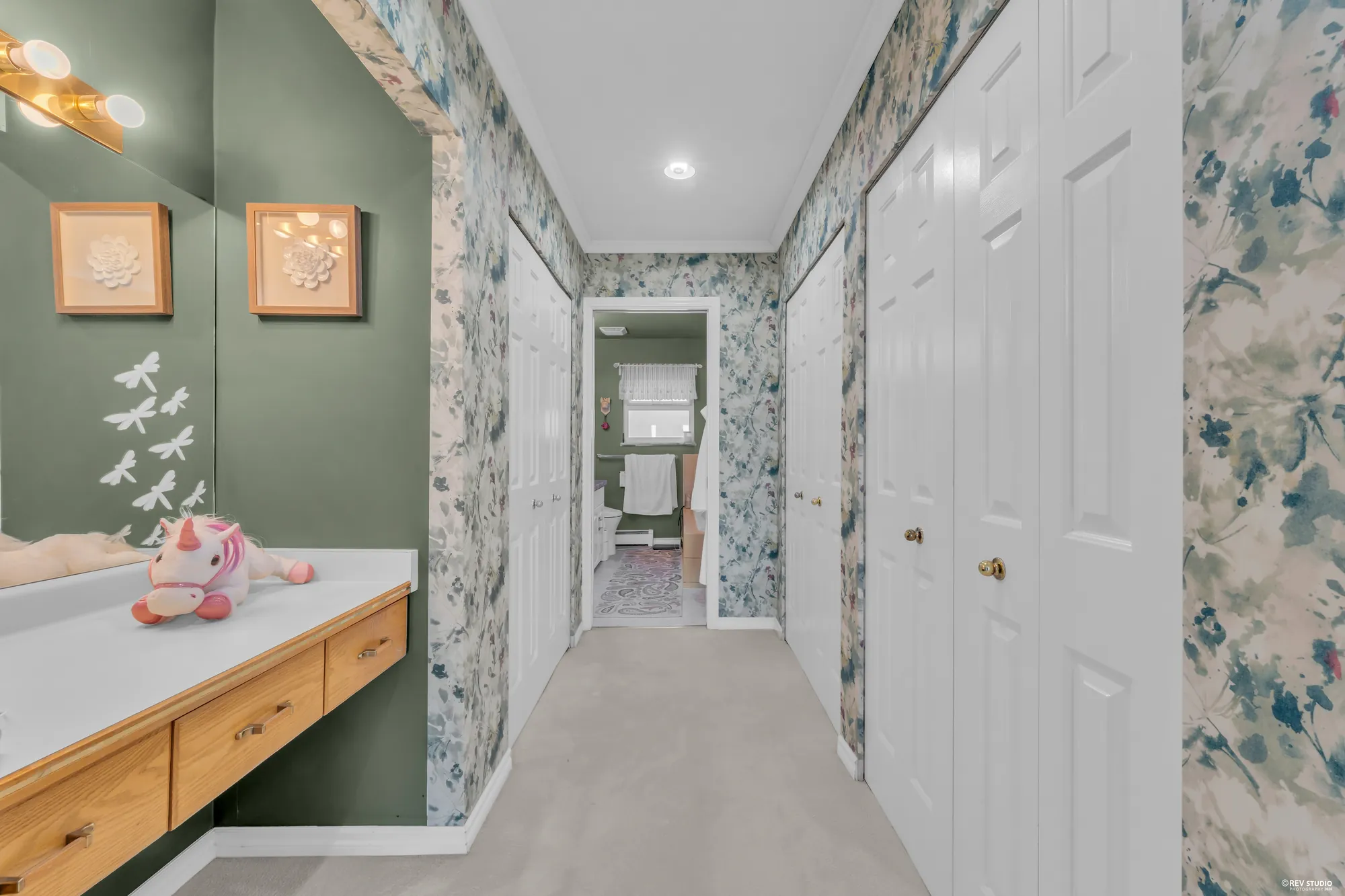 The upper hall: a dressing counter under a light, closets along the wall, the bathroom at the end