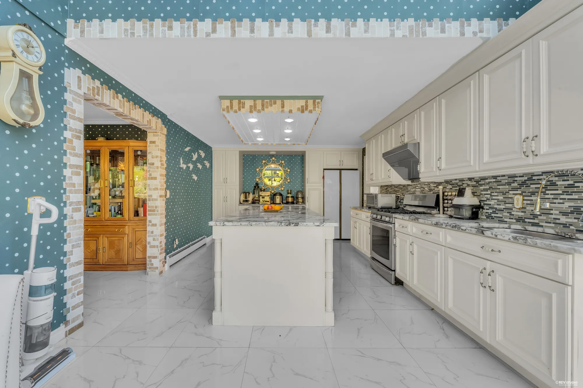 Down the length of the kitchen from the hall, a china cabinet on the left