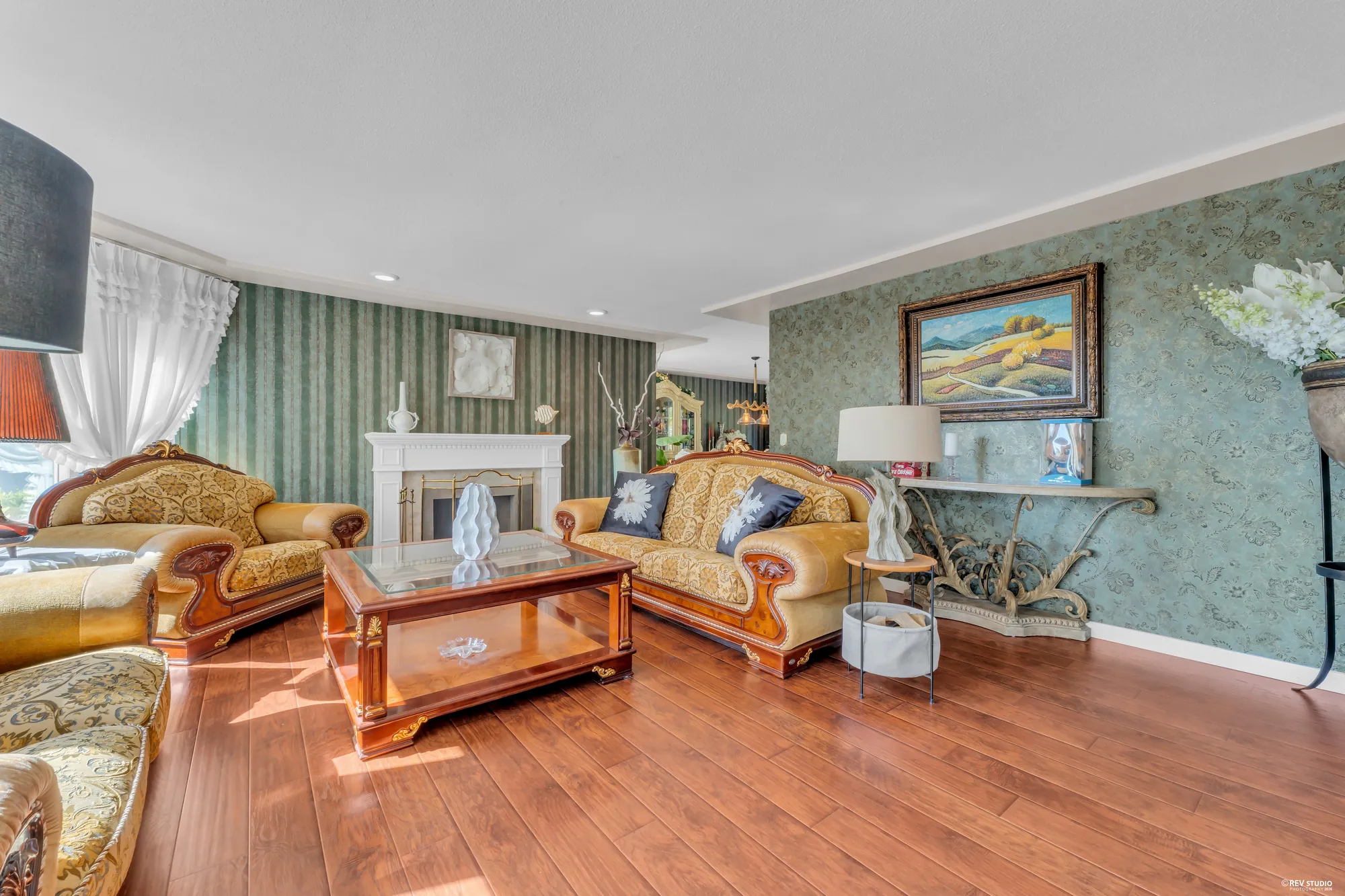 The living room from the dining room: the fireplace, the sofas, the bay window on the right