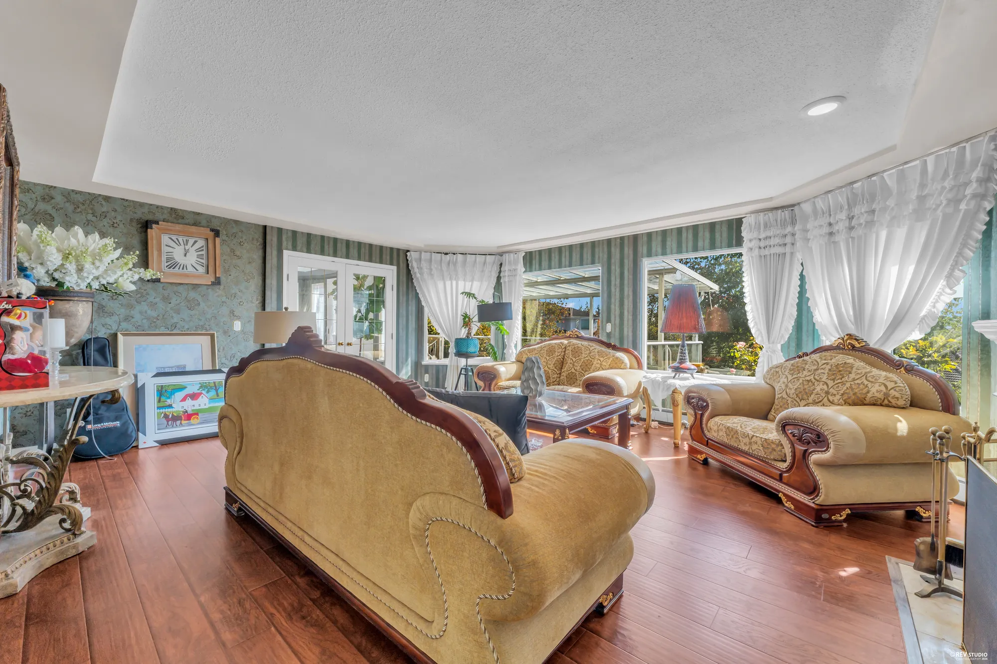 The living room from the foyer: the sofas, the windows to the front with their curtains