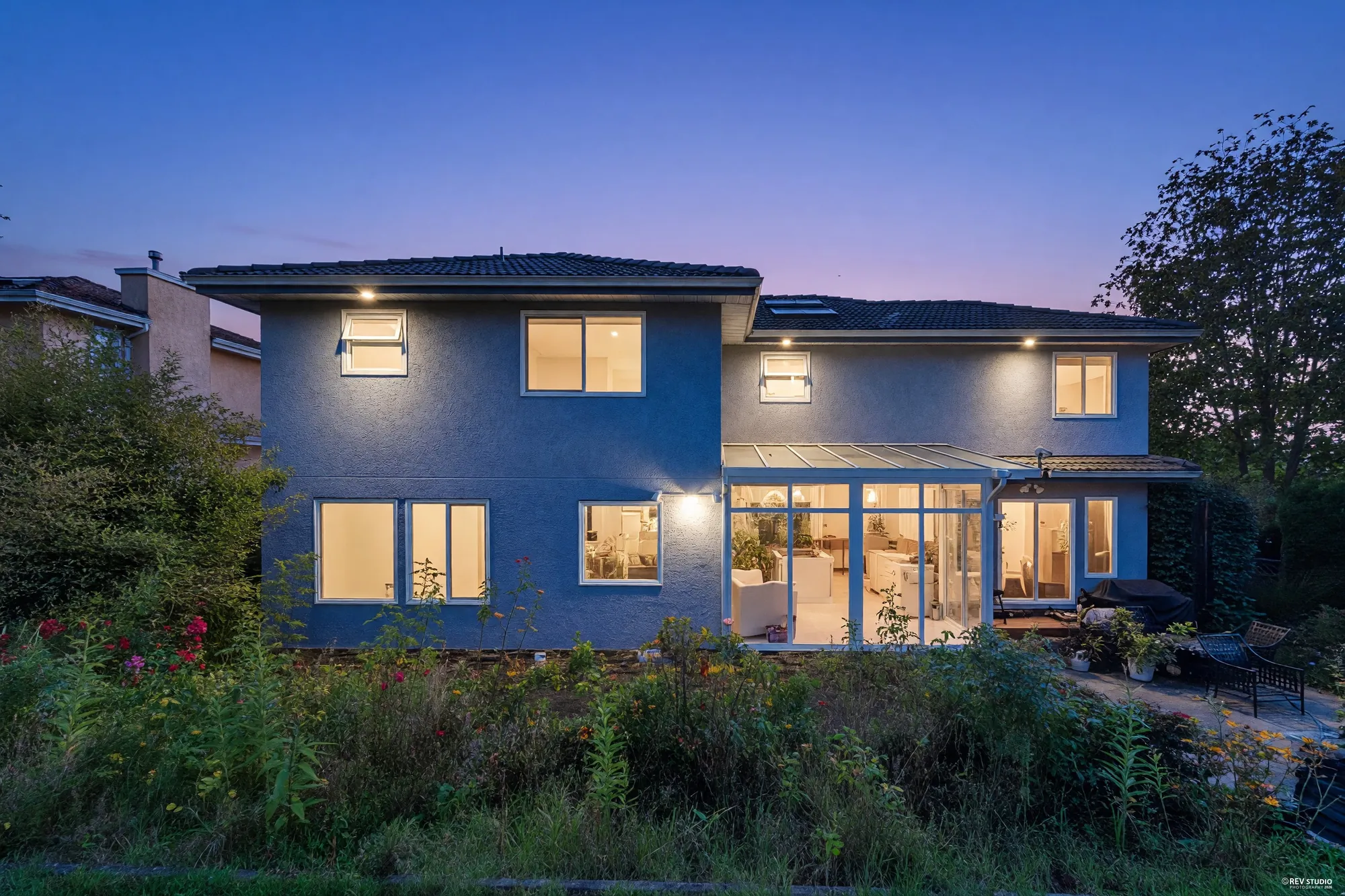 The same view of the back at dusk, every window lit